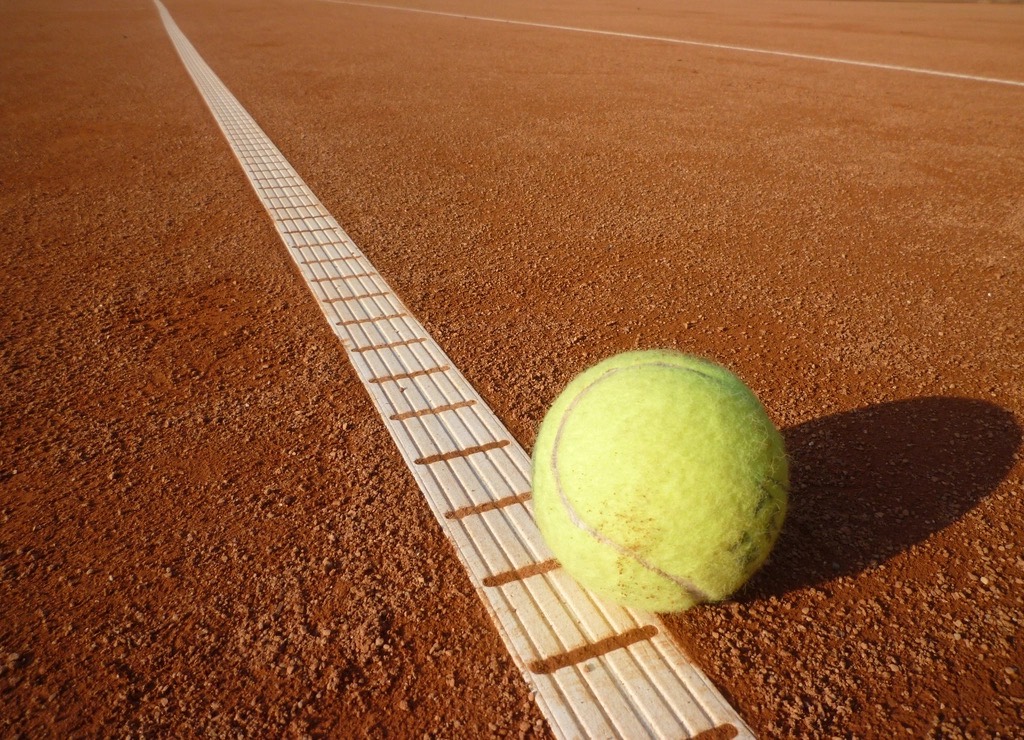 Tennis ball on the line of a clay court