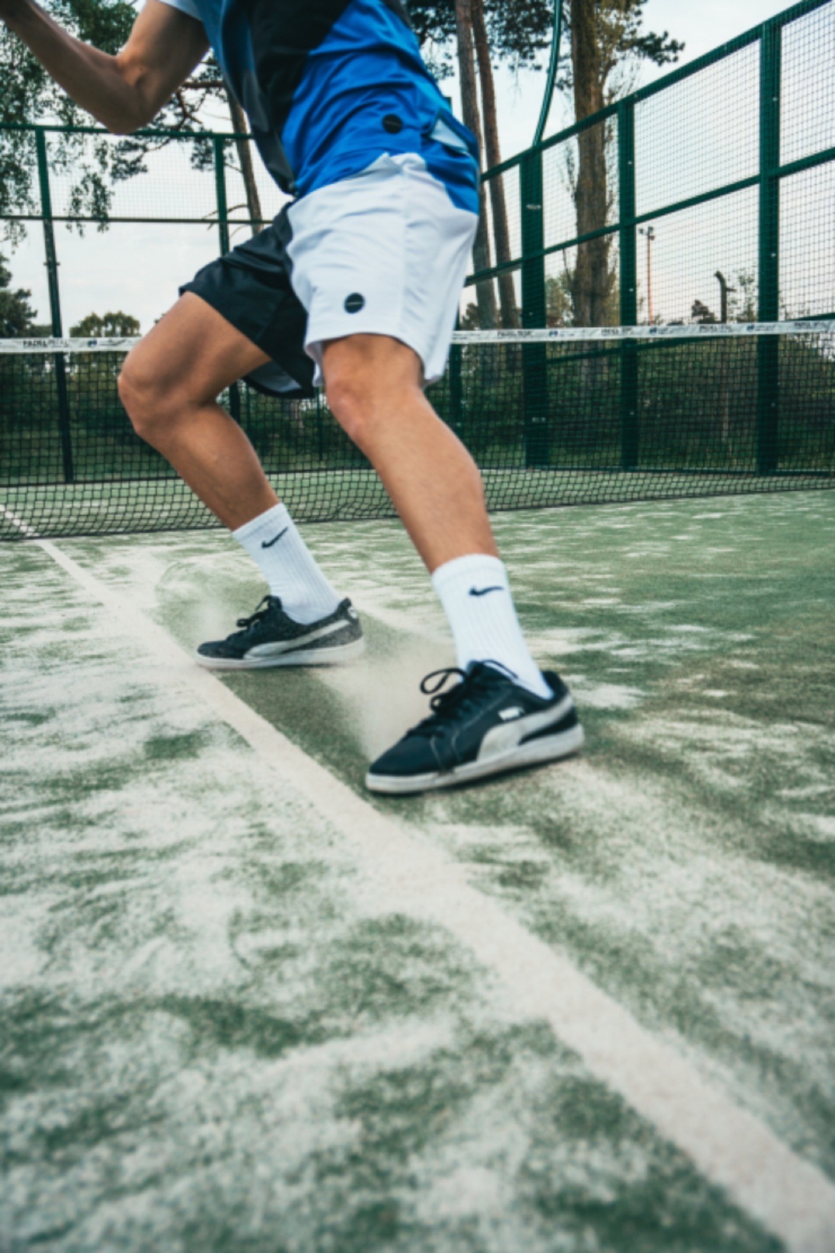 Padel player sprinting across a green court